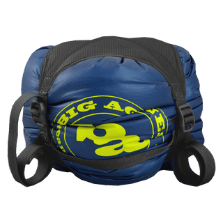 A blue and yellow Big Agnes Superlight Girdle with black straps is cinched tightly on a white background—ideal for compressing your sleeping bag and streamlining gear storage.